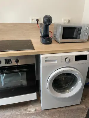 a kitchen with a microwave and a washing machine at Studio design hypercentre Gare & espresso offert in Castelnaudary