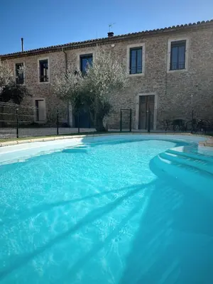 a large blue swimming pool in front of a building at Au cocon des corbières - Élégance in Lézignan-Corbières
