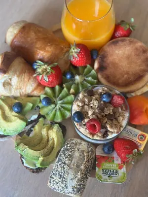 a plate of breakfast food with fruit and a glass of orange juice at Au cocon des corbières - Élégance in Lézignan-Corbières