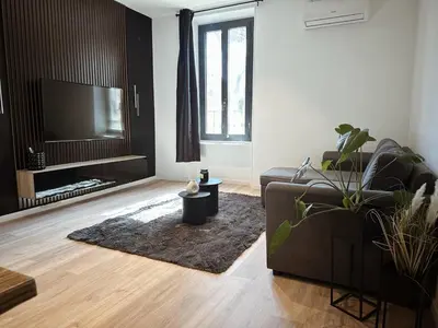 a living room with a couch and a flat screen tv at Au cocon des corbières - Élégance in Lézignan-Corbières