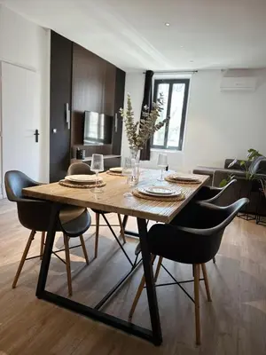 a dining room with a wooden table and chairs at Au cocon des corbières - Élégance in Lézignan-Corbières