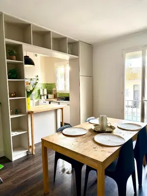 a kitchen and dining room with a wooden table and chairs at Appartement Narbonne centre in Narbonne