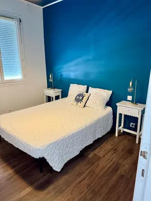 a bedroom with a bed and a blue wall at Appartement Narbonne centre in Narbonne