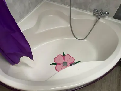 a white bath tub with a pink flower painted on it at Appartement au cœur de Mirepoix in Mirepoix