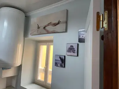 a hallway with a window and pictures on the wall at Appartement au cœur de Mirepoix in Mirepoix