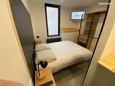 a small bedroom with a bed and a television at Gîte la Cave in Quarante