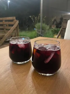 two glasses of soda sitting on a wooden table at Les volets verts in Saint-Laurent-de-la-Cabrerisse