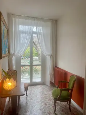 a room with a window and a table and a chair at Les volets verts in Saint-Laurent-de-la-Cabrerisse