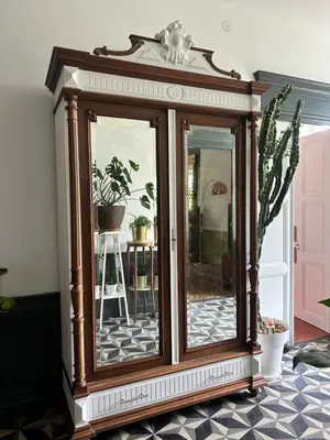 a wooden display cabinet in a room with plants at Les volets verts in Saint-Laurent-de-la-Cabrerisse