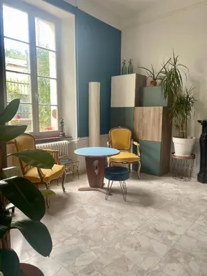 a room with chairs and a table and a table at Les volets verts in Saint-Laurent-de-la-Cabrerisse