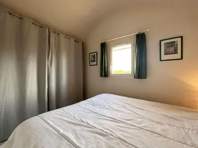 a bedroom with a white bed and a window at Pavillon Bora Bora, 2 salles d eau et piscine - GA090-002 in Gruissan