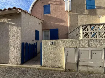 a building with blue doors on the side of it at Pavillon Bora Bora, 2 salles d eau et piscine - GA090-002 in Gruissan