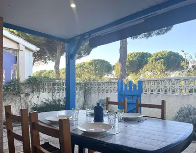 a blue table with chairs on a patio with a view at Pavillon Bora Bora, 2 salles d eau et piscine - GA090-002 in Gruissan