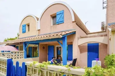 a house with blue doors and a fence at Pavillon Bora Bora, 2 salles d eau et piscine - GA090-002 in Gruissan