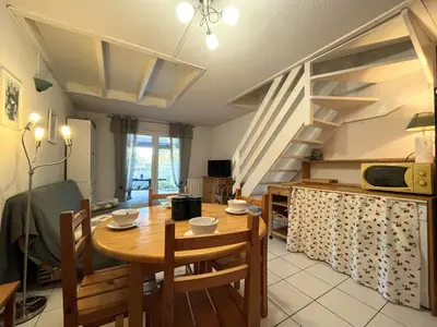 a kitchen and dining room with a wooden table and chairs at Pavillon Bora Bora, 2 salles d eau et piscine - GA090-002 in Gruissan