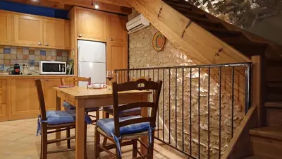 a kitchen with a wooden table and chairs in a kitchen at Avalon in Caunes-Minervois