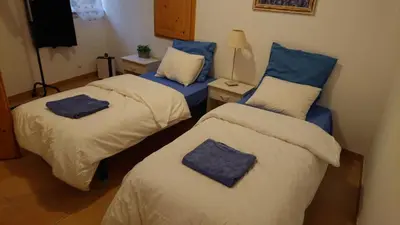 two beds in a room with blue pillows on them at Avalon in Caunes-Minervois