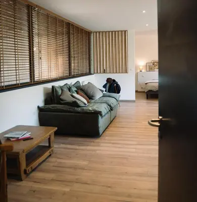 a person sitting on a couch in a living room at Cavalier Loft Domaine de Greffeil in Greffeil
