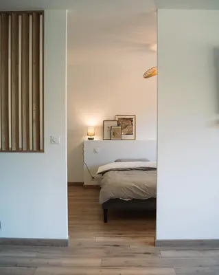 a bedroom with a bed in a room with white walls at Cavalier Loft Domaine de Greffeil in Greffeil
