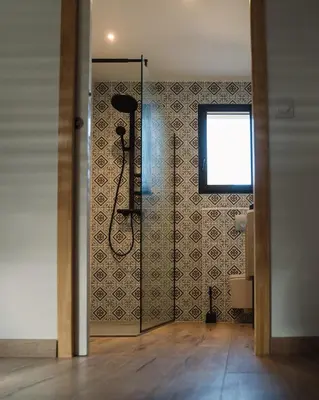 a bathroom with a shower with a tile wall at Cavalier Loft Domaine de Greffeil in Greffeil