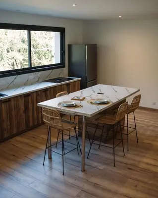 a kitchen with a table with chairs and a refrigerator at Cavalier Loft Domaine de Greffeil in Greffeil