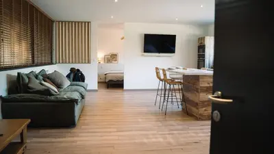 a living room with a couch and a kitchen with a table at Cavalier Loft Domaine de Greffeil in Greffeil