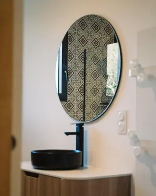 a mirror on top of a sink in a bathroom at Cavalier Loft Domaine de Greffeil in Greffeil