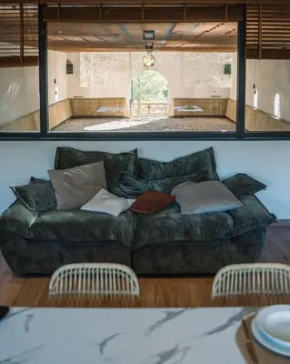 a living room with a green couch in a room at Cavalier Loft Domaine de Greffeil in Greffeil