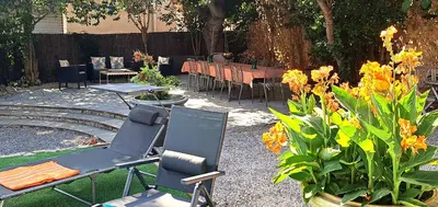 a patio with a table and chairs and flowers at Le MAS CLEMENTINE in Puisserguier