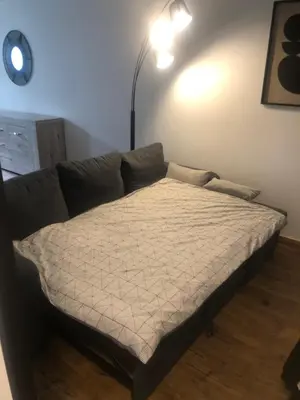 a bed in a living room next to a couch at APPARTEMENT F3 BOX Vélo Moto Centre historique in Mirepoix