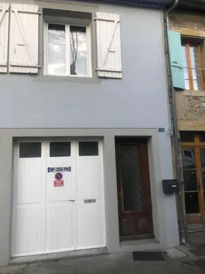 two white garage doors on a white building at APPARTEMENT F3 BOX Vélo Moto Centre historique in Mirepoix