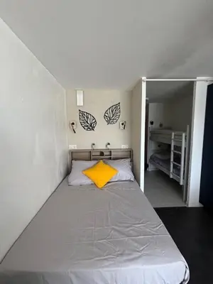 a small bedroom with a bed with a yellow pillow at Studio Cabine Vue Port Gruissan in Gruissan