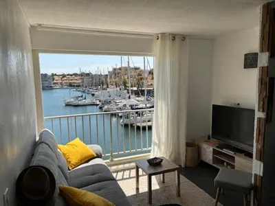a living room with a view of a marina at Studio Cabine Vue Port Gruissan in Gruissan