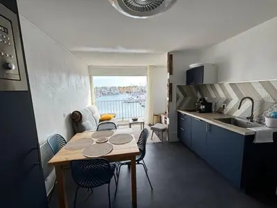 a kitchen with a table and chairs in a kitchen at Studio Cabine Vue Port Gruissan in Gruissan