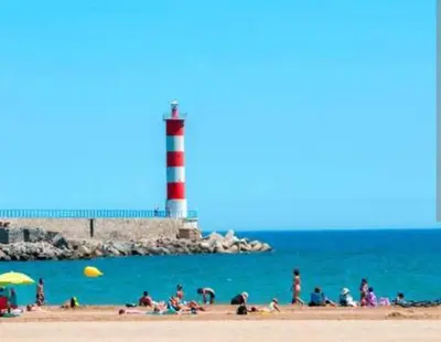 a group of people on the beach with a lighthouse at Vue lac & mer à pied - Séjour détente in Port-la-Nouvelle