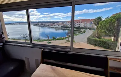 a view of a river from a window at Vue lac & mer à pied - Séjour détente in Port-la-Nouvelle
