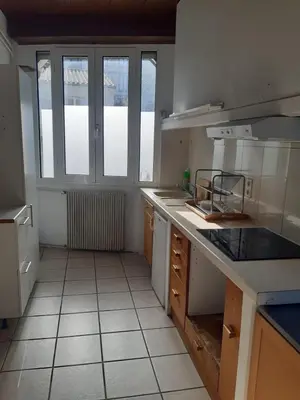 a kitchen with white tile floors and a large window at Maison 3 chambres - 25mn de Toulouse in Caraman