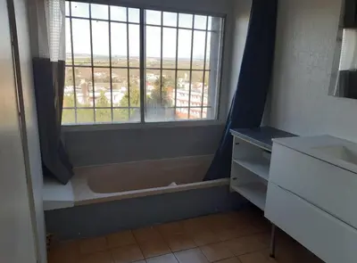 a bathroom with a window and a dresser and a sink at Maison 3 chambres - 25mn de Toulouse in Caraman