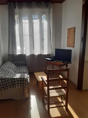 a bedroom with a bed and a desk with a laptop at Maison 3 chambres - 25mn de Toulouse in Caraman
