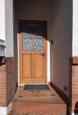 a wooden door with a window on a building at Maison 3 chambres - 25mn de Toulouse in Caraman