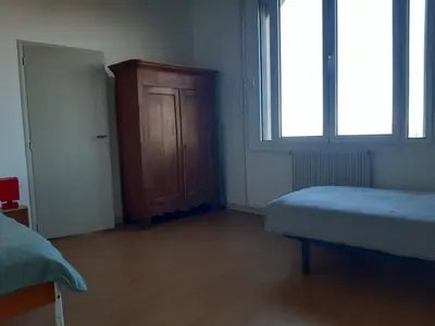 a bedroom with a bed and a wooden cabinet at Maison 3 chambres - 25mn de Toulouse in Caraman