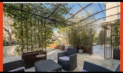 a patio with chairs and trees and a building at Casa Alegria in Portel-des-Corbières