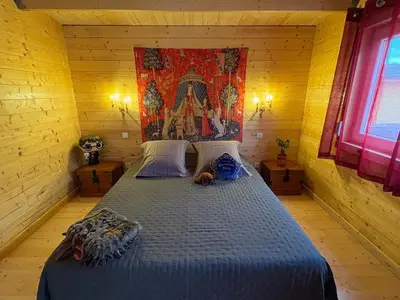 a bedroom with a large bed in a wooden room at HARRY POTTER-Chalet du Sanglier Magique - in Boutenac