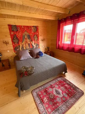 a bedroom with a bed in a log cabin at HARRY POTTER-Chalet du Sanglier Magique - in Boutenac