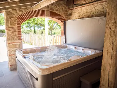 a jacuzzi tub in a building with an arch at Domaine de Vadel in Veilhes