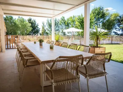 a large wooden table and chairs on a patio at Domaine de Vadel in Veilhes