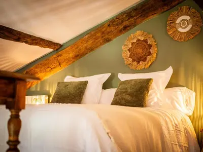 a bedroom with a bed with white sheets and pillows at Domaine de Vadel in Veilhes