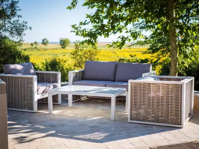 a patio with a couch and two chairs and a table at Domaine de Vadel in Veilhes