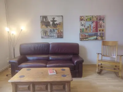 a living room with a brown leather couch and a coffee table at Appartement exceptionnel Bastide St Louis in Carcassonne