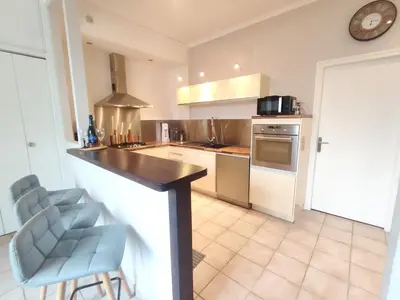 a kitchen with a counter and some chairs in it at Appartement exceptionnel Bastide St Louis in Carcassonne